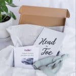 A close up of the white set. It contains a Head-to-Toe Prayer Journal, a Scripture Promises Labor and Birth Card set, and a baby hat