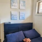 The "Warrior for Truth: Printable wall art" printed on canvases and hanged over the top of a bed. On the bed are blue covers and pillows as well as a stuffed dinosaur.