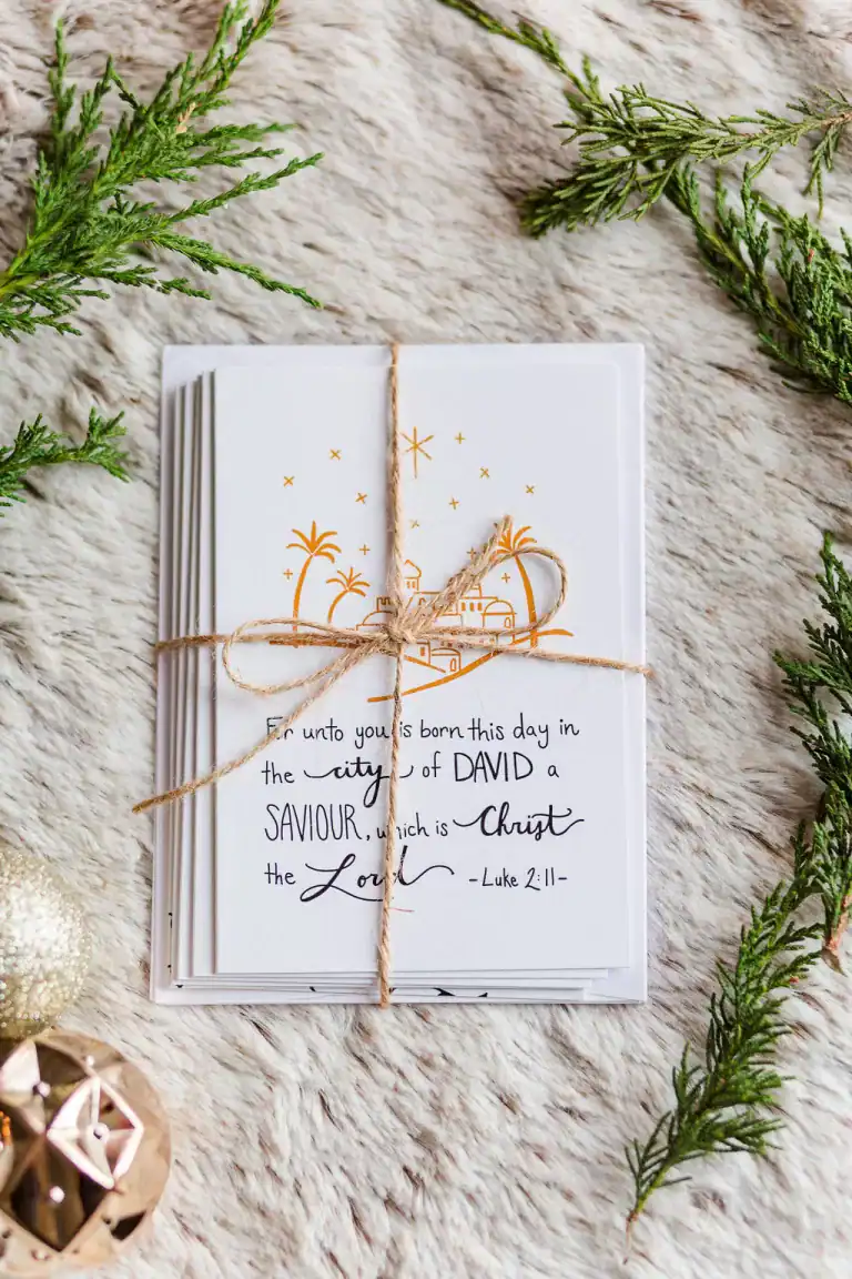 Beautiful Christmas Cards wrapped in a twine bow and laid on soft fir with pine branches around it.