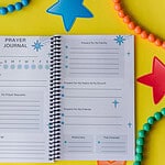 The Prayer Journal on yellow paper surrounded by beads. It is open to the main prayer request page.