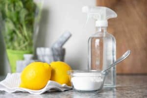 Fresh lemons with cleaning supplies and disinfectant spray for natural cleaning.