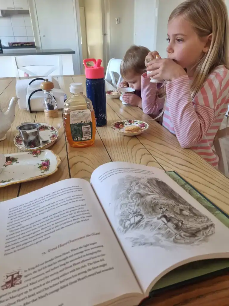 1. Kids enjoying breakfast while reading a storybook at a cozy kitchen table.