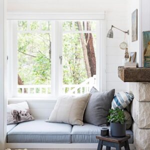 Comfortable window nook with cozy cushions in a serene, nature-inspired setting for relaxation and reflection.